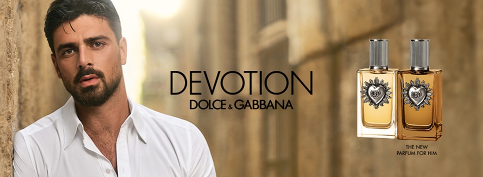 Werbebild für Dolce & Gabbana Devotion. Links steht ein Mann mit Bart in weißem Hemd in einer sonnigen Gasse, rechts sind zwei Parfumflakons mit silbernem Verschluss und Herz-Emblem abgebildet. In der Mitte der Schriftzug Devotion Dolce & Gabbana.