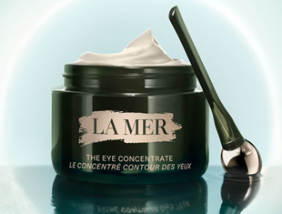 Kategoriebild Augenpflege von La Mer: Dunkelgrüner Cremetiegel mit der Aufschrift ›The Eye Concentrate‹ steht geöffnet neben einem Applikator vor hellem Hintergrund.