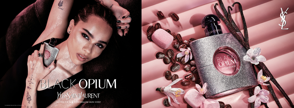 Werbeanzeige für das Parfum 'Black Opium' von Yves Saint Laurent. Links liegt eine Frau mit zurückgelegtem Kopf und intensivem Blick, die ein glitzerndes Parfumfläschchen in der Hand hält. Ihre Haut wird von rosa Licht angestrahlt. Rechts ist das gleiche Parfumfläschchen in Nahaufnahme zu sehen – glitzernd silber mit rosa Inhalt und schwarzem Verschluss, umgeben von rosa Marshmallows, Kaffeebohnen, Vanilleschoten und weißen Blüten auf einem rosa gestreiften Hintergrund. Oben rechts das YSL-Logo, unten links der Schriftzug 'Black Opium – The New Irresistible Marshmallow Musk Scent'.